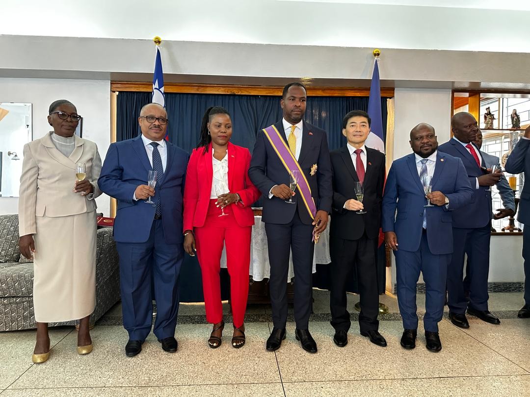 胡大使與潘恩大使(前排左四)、總統委員歐古斯丁(Smith AUGUSTIN，左六)、總統委員吉爾傑(Dr. Louis Gérald GILLES、左二)、潘恩大使夫人暨總統府新聞室主任Daniella JACQUES(左三)及潘恩大使母(左一)合影