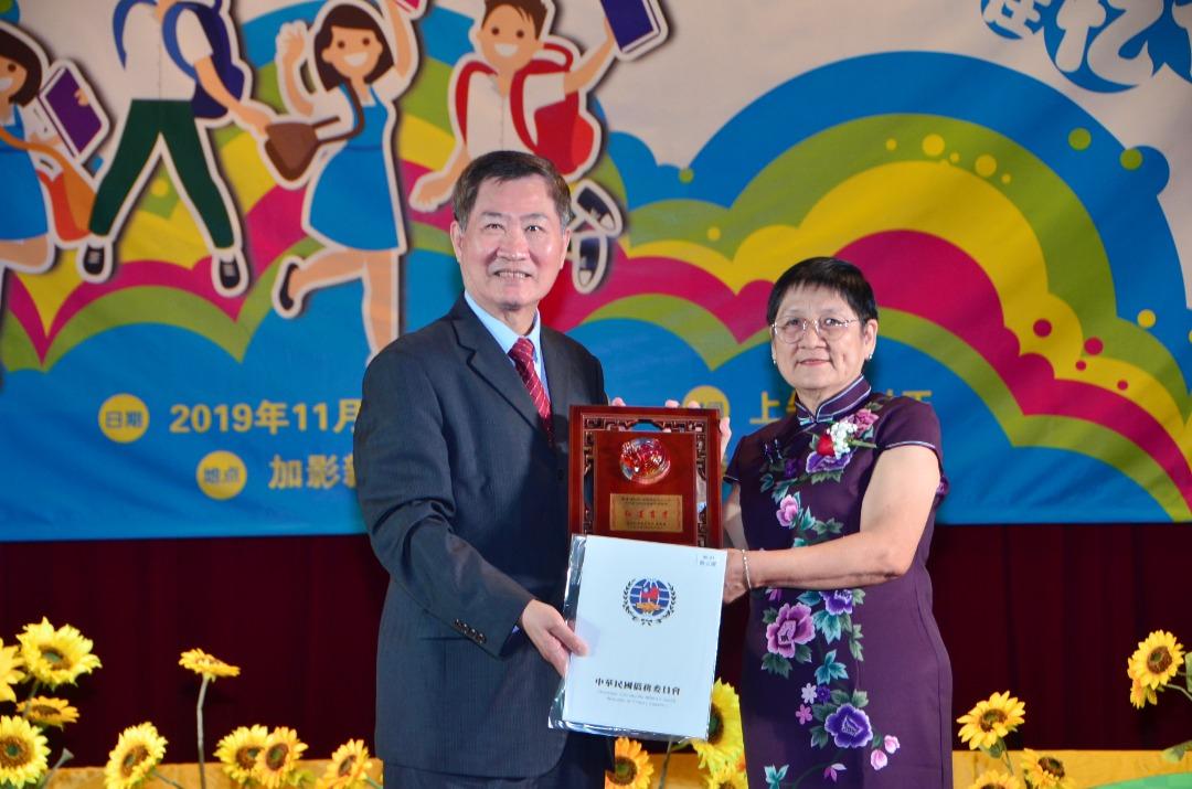 Timbalan Wakil Michael S.Y.Yiin (kiri)memberi anugerah Overseas Chinese Affairs Commission kepada guru Joon Mee Chin yang berkhidmat selama 50 tahun.