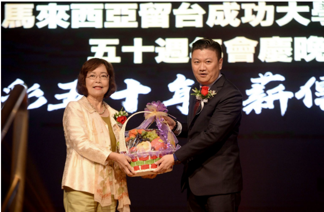 Tey Tek Len, Presiden Persatuan Siswazah-siswazah Taiwan Cheng Kung Universiti, Malaysia, menyampaikan sebakul buah-buahan kepada Wakil Anne Hung.
